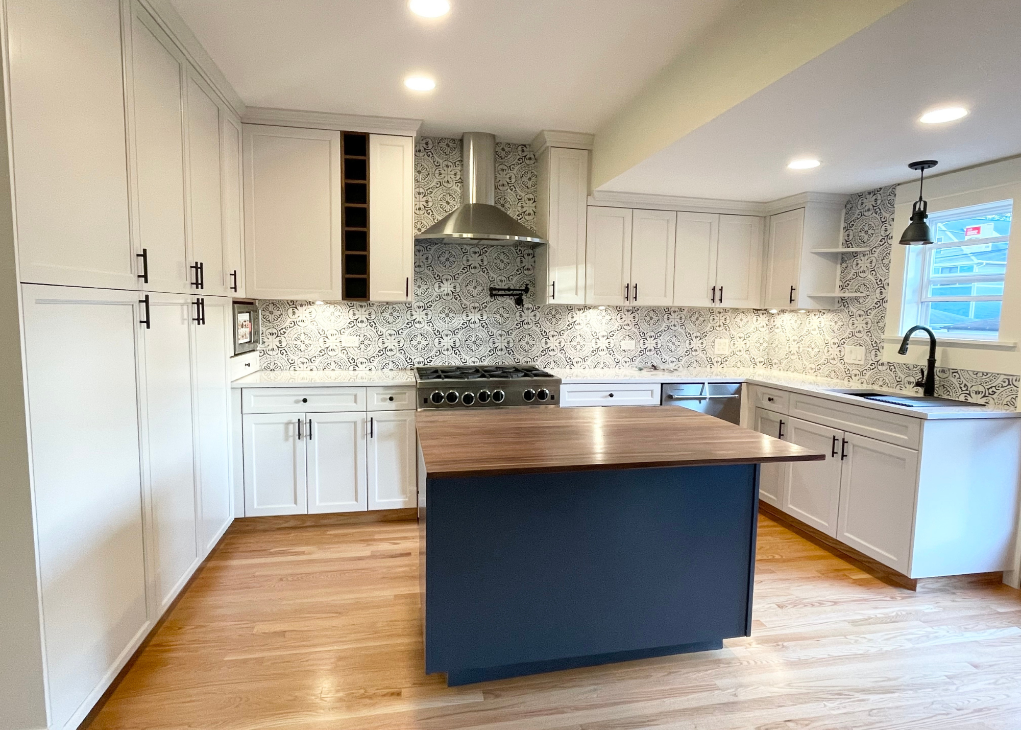 Sherwin williams navy blue custom island with black walnut countertop and custom contemporary kitchen cabinets by BradleyBuilt